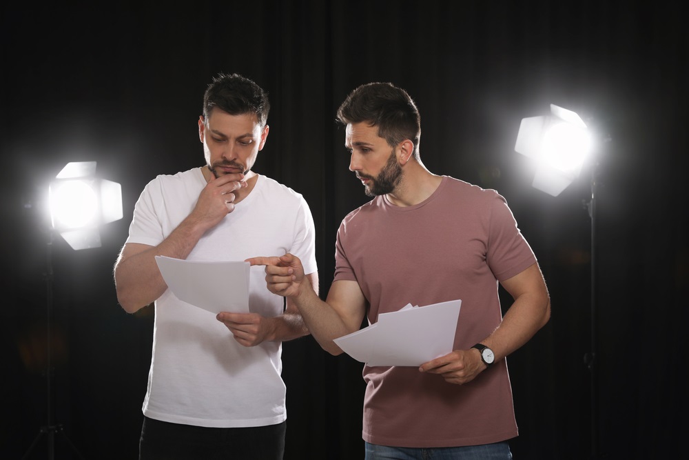 A casting director reviewing headshots and resumes during the actor booking process.