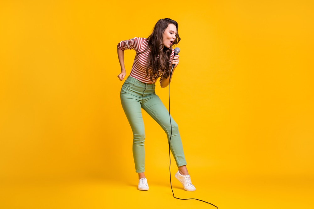 A background singer performing passionately during a live concert.
