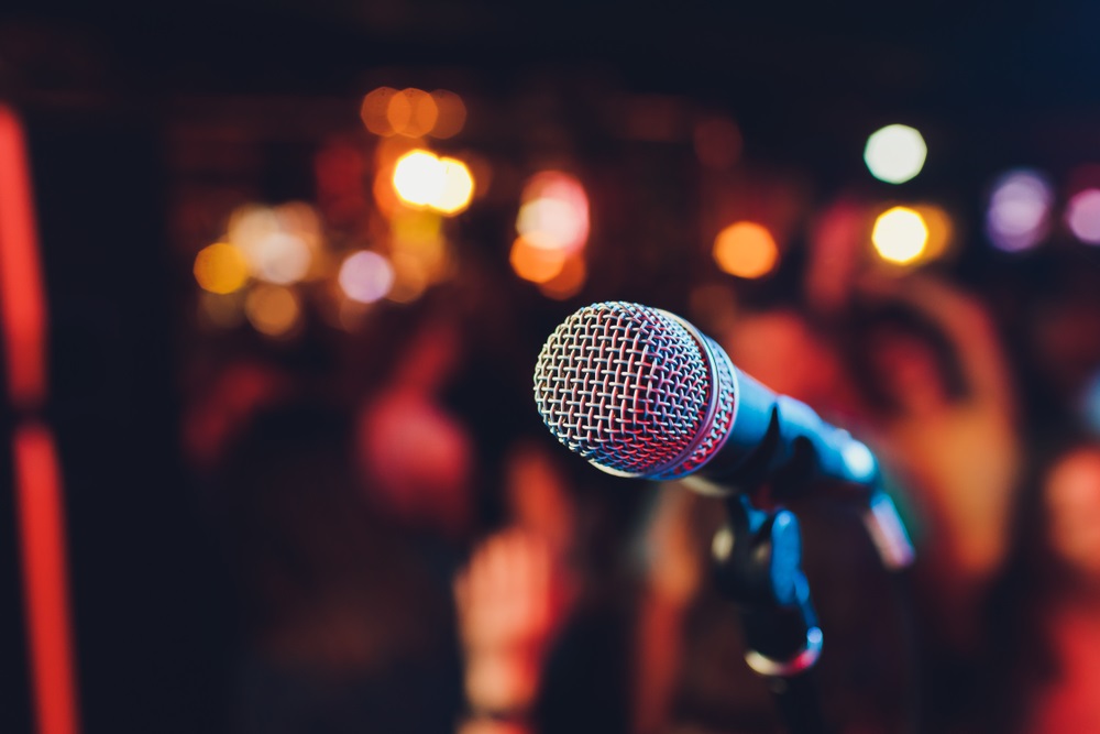 A background singer performing passionately during a live concert.
