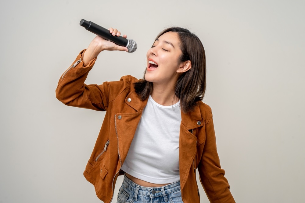 A background singer performing passionately during a live concert.
