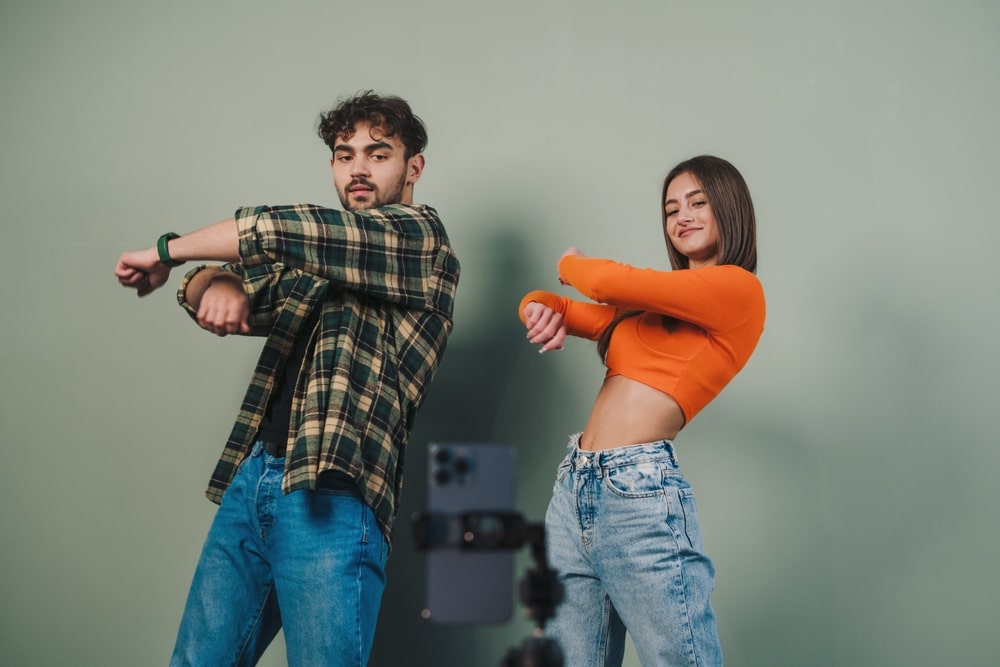 Dancers rehearsing in a professional dance studio with mirrored walls.