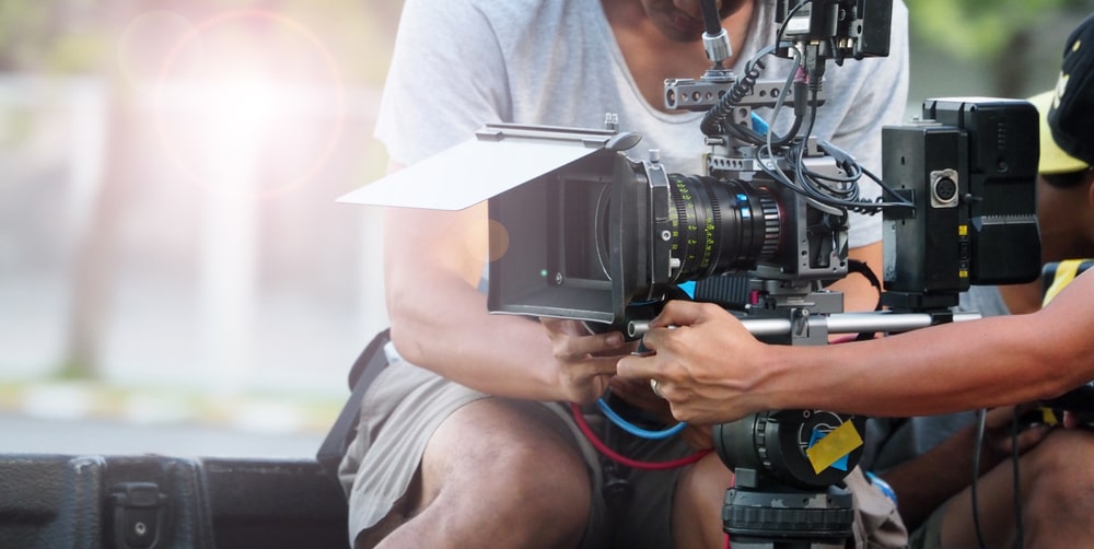 Aspiring filmmaker working with a camera crew on a movie set.