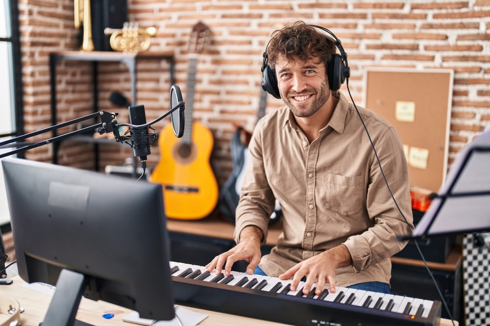 Aspiring musician playing guitar and recording a demo in a professional studio.