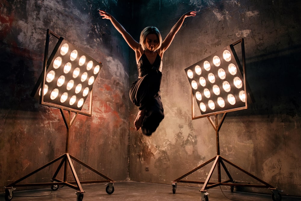 Professional dancer performing on stage with dramatic lighting.