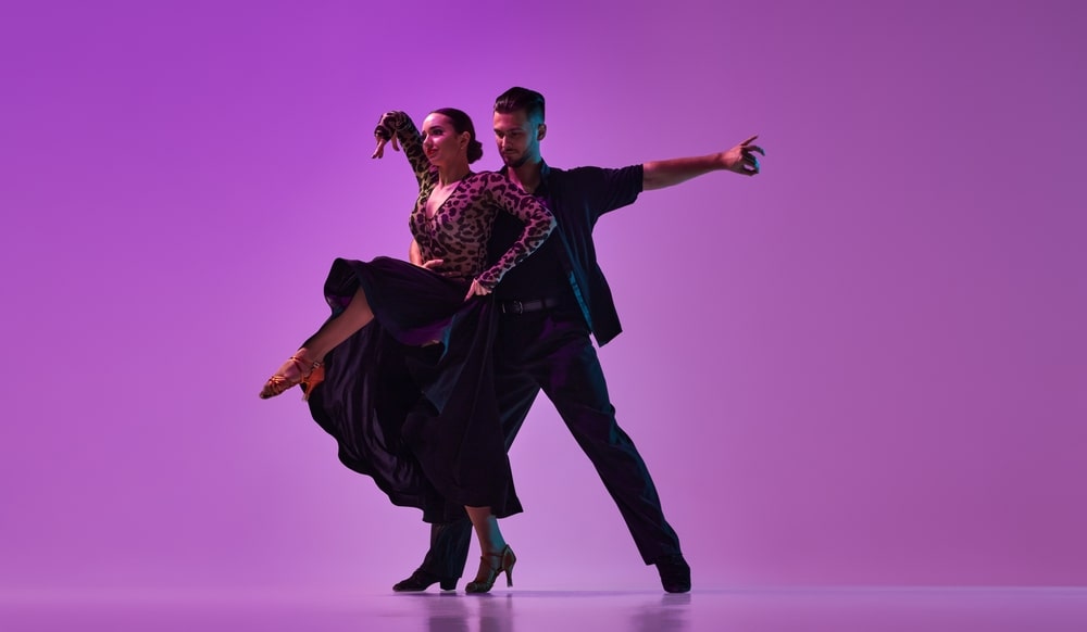 Professional dancer performing on stage with dramatic lighting.