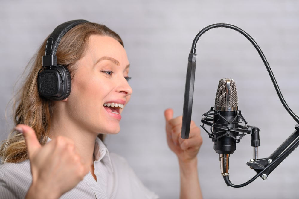 A teenage girl recording her voice for a voice acting job in a home studio.