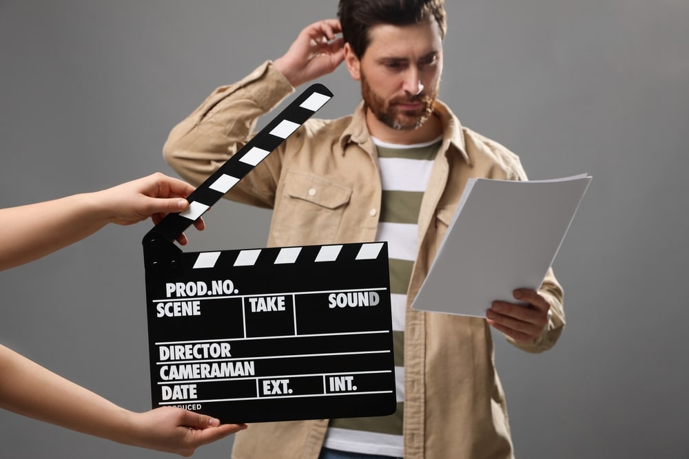 An actor performing on stage while reading a script.
