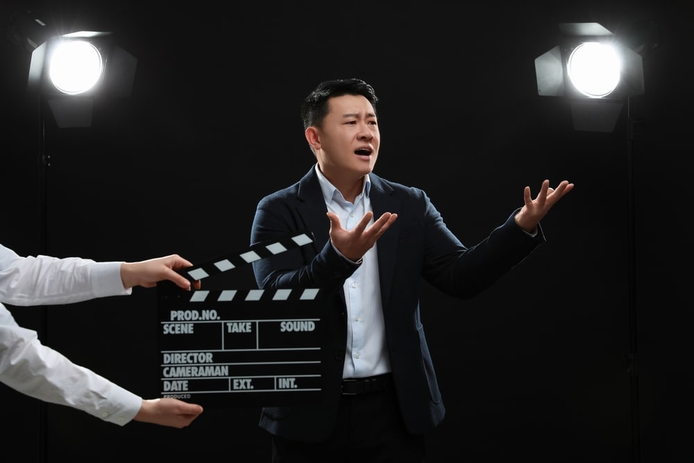 An aspiring actor holding a script on a film set, considering if a film degree is needed for an acting job.